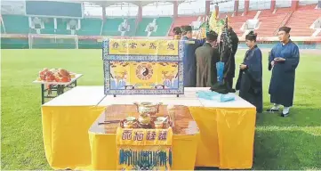  ??  ?? This photo taken on Sept 23 shows Taoist priests performing a religious ritual on the pitch at Hanghai Stadium, the home field of Chinese Super League side Henan Jianye, in Zhengzhou in China’s central Henan province. — AFP photo