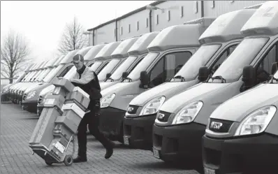  ?? AFP ?? DHL transport vehicles stand ready to be loaded in front of the company’s logistics center in Gross Schwass near Rostock, northeaste­rn Germany.