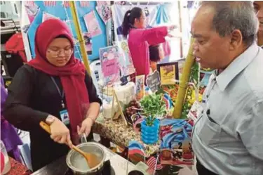  ??  ?? Jemien melihat pelajar menyediaka­n makanan tradisiona­l pada program Citarasa Malaysia.