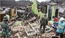  ?? HENDRA PERMANA AP ?? Indonesian soldiers help clear up rubble at a house damaged by an earthquake in Malang, East Java, Indonesia, on Sunday. The deadly earthquake on Indonesia’s main island of Java damaged multiple buildings, officials saidnami.