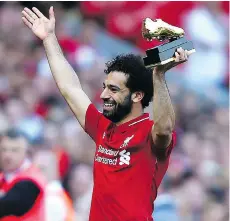  ?? ASSOCIATED PRESS ?? Mohamed Salah hoists his Golden Boot award after his Liverpool side beat Brighton 4-0 on Sunday to secure another season in the Champions League. Salah led the Premier League with 32 goals.