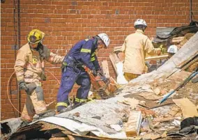  ?? JERRY JACKSON/BALTIMORE SUN ?? Firefighte­rs search the rubble of several rowhouses after a gas explosion ripped through homes in Northwest Baltimore.