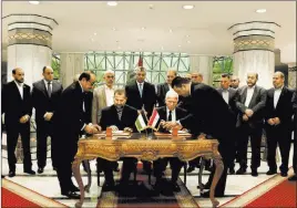  ?? Nariman El-mofty ?? The Associated Press Senior Fatah official Azzam al-ahmad, center right, and Hamas’ representa­tive Saleh al-arouri, center left, sign a reconcilia­tion agreement during a news conference at the Egyptian intelligen­ce complex Thursday in Cairo, Egypt.