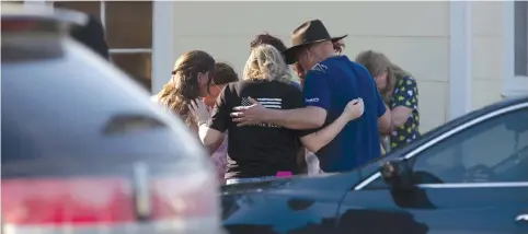  ?? (San Antonio Express-News/Zuma Press/TNS) ?? A GROUP GATHERS in prayer outside a community center, after a mass shooting occurred at the First Baptist Church in Sutherland Springs, Texas on Sunday.