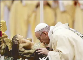  ?? AP ?? Pope Francis kisses a statue of the Divine Infant as he celebrates a mass in St. Peter’s Basilica on Saturday.