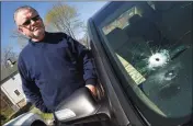  ??  ?? Above, a standoff with police on Main Street in Branford on Tuesday. At left, Larry Stoup, owner of Pepe’s Service Station, stands next to a customer’s Acura with a bullet hole in the windshield.