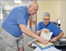  ??  ?? Leland Harvie, left, and Hantsport Historical Society president Judson Porter pore over historical documents inside the Dorie and Garnet McDade Heritage Centre. They say new discoverie­s are made all the time about Hantsport’s history and its residents.