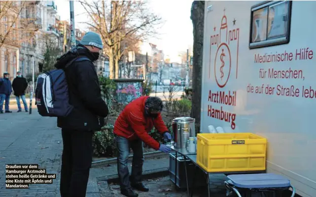  ??  ?? Draußen vor dem Hamburger Arztmobil stehen heiße Getränke und eine Kiste mit Äpfeln und Mandarinen.