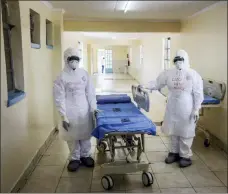  ?? KHALIL SENOSI — THE ASSOCIATED PRESS ?? Kenyan nurses Maggie Ogonga, left, and Lucy Kanyi, right, with names written on their protective clothing so they can be recognized when wearing it, demonstrat­e the facilities and protective equipment to members of the media, during a visit to the recently-completed infectious disease unit of Kenyatta National Hospital, located at Mbagathi Hospital, in the capital Nairobi, Kenya March 6. Kenya does not yet have a confirmed case of the new virus, but the ward will be used to isolate and treat coronaviru­s cases if they are identified in the country.