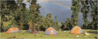  ??  ?? National Outdoor Leadership School students’ tents are setup while on a backpackin­g course in India as a rainbow can be seen from their tents while they explore India’s Pindari region. — AP photos