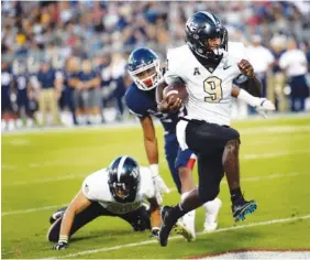  ?? ASSOCIATED PRESS PHOTOS BY STEPHEN DUNN ?? UCF running back Adrian Killins Jr. runs for a touchdown during the first half of Thursday’s season opener against UConn in East Hartford, Conn. The visiting Knights won 56-17.