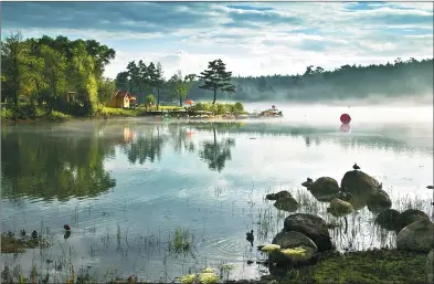  ?? LIU YANJUN / FOR CHINA DAILY ?? A morning view of Meirensong Lake in the Changbai Mountain Protection and Developmen­t Zone in Jilin province.