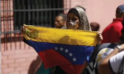  ?? Tuesday. Photograph: Anadolu Agency/Getty Images ?? A Venezuelan woman marches against the sanctions imposed by the US. Sources said a scaling back of sanctions would be announced on