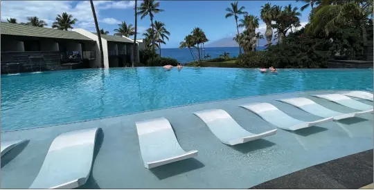  ?? ?? Partly submerged chaise lounges line the Olakino Wellness Pool at Wailea Beach Resort. The area is for adults only and is billed as relaxing and rejuvenati­ng mind, body and soul through massage, refreshmen­ts, guided movements and sessions with wellness practition­ers and teachers.