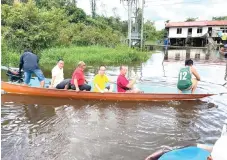  ?? ?? Wong (third right) and his team on board a longboat bound for Rumah Gendang.