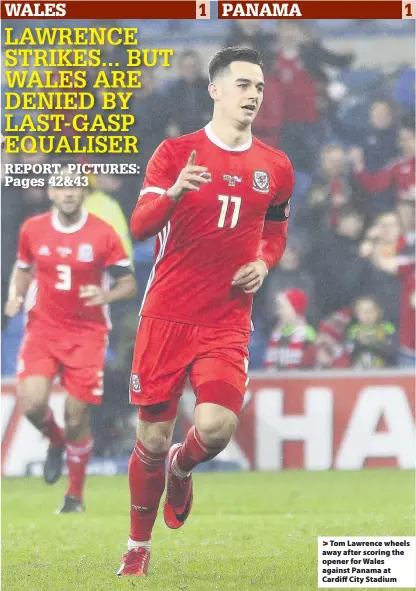  ??  ?? > Tom Lawrence wheels away after scoring the opener for Wales against Panama at Cardiff City Stadium