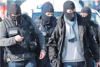  ??  ?? Gun police return to their vehicles after they stormed the supermarke­t yesterday