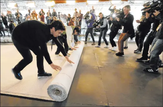  ?? Chris Pizzello The Associated Press ?? A champagne-colored carpet outside the Dolby Theatre is rolled out Wednesday in preparatio­n for Sunday’s Academy Awards.