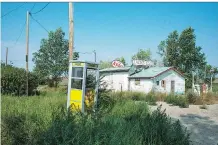  ??  ?? This 1986 photo captures an abandoned gas station and phone booth.