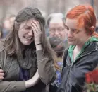  ?? JULIO CORTEZ/AP ?? After Emma MacDonald was photograph­ed at a vigil for the victims of the Boston Marathon bombing in April 2013, the image went viral and a “crisis actors” conspiracy theory took hold.