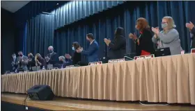  ?? SCREENSHOT OF NPTV VIDEO ?? North Penn school board members and administra­tors applaud for superinten­dent Curt Dietrich, seated at center, after formally accepting his notice of retirement during the school board’s Feb. 17.