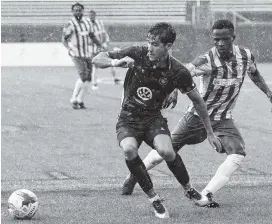  ?? STAFF PHOTO BY C.B. SCHMELTER ?? Chattanoog­a FC’s Jose Francisco Ferraz, left, works against the Georgia Revolution’s Carl Adjaho at Finley Stadium on Tuesday.