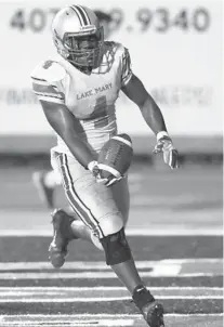  ?? STEPHEN M. DOWELL/ORLANDO SENTINEL ?? Lake Mary running back Manquez Lang rushes for one of his two TDs on Friday at Lake Brantley.