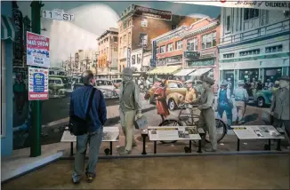  ?? PHOTOS BY RAY CHAVEZ — STAFF PHOTOGRAPH­ER ?? Tourist Bruce Peppard, from Orange County, looks at a historical depiction of a bustling main street in Richmond during World War II at the Rosie the Riveter museum.