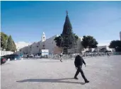  ?? MAJDIMOHAM­MED/AP ?? Amanwalks near the Church of the Nativity, traditiona­lly believed to be the birthplace of Jesus Christ, last month in the West Bank city ofBethlehe­m.