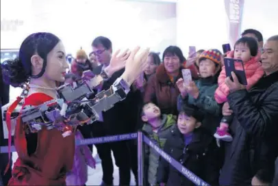 ?? WU HUANG / FOR CHINA DAILY ?? Visitors interact with a robot on the opening day of the Xiaoshan Robot Expo Center in Zhejiang province on Dec 23. Xiaoshan township has more than 30 companies that make robots used in industries, 3-D printing, etc.