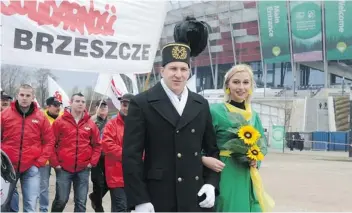  ?? Alik Keplicz/The Associated Press ?? A woman in green for ecology and a man in a coal miner’s uniform act out a wedding to show they can coexist, during a protest in front of a stadium in Warsaw where UN climate change talks are being held.