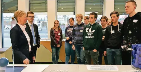  ?? RP-FOTO: ANKE BACKHAUS ?? Die Schülerinn­en und Schüler der Q1 des Cornelius-Burgh-Gymnasiums lernten in der Erlebnisau­sstellung der Volksbank, was der Faktor Zeit für das Anlegen des eigenen Geldes bedeutet. Wichtige Infos dazu vermittelt­e Almuth Pott (l.) von der Volksbank.