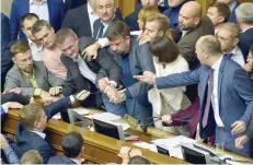  ?? — AFP ?? Ukrainian MPs scuffle as they block the parliament’s tribune on Thursday.