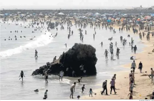  ?? EUGENE GARCÍA / EFE ?? Imagen panorámica de la playa california­na de Newport abarrotada de gente en el ‘Memorial Day’ que celebró ayer lunes Estados Unidos.