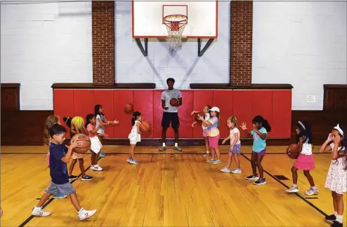  ?? Ned Gerard / Hearst Connecticu­t Media ?? UConn forward Richie Springs works with summer campers during a visit Monday to the Wakeman Boys & Girls Club in Fairfield.