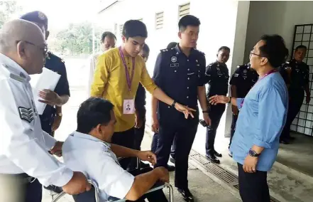  ??  ?? Hands-on approach: Razali (right) and Syed Saddiq (in yellow) campaignin­g during the early vote at the Taman Perumahaan Police Perupok multipurpo­se hall in Muar.