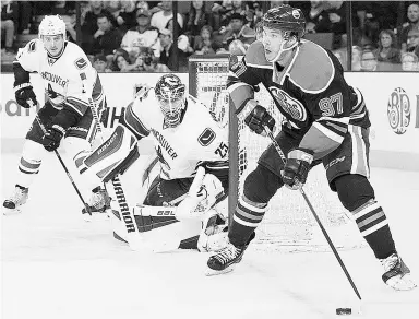  ?? Jason Franson / The Cana dian Press ?? Vancouver Canucks goalie Jacob Markstrom and Dan Hamhuis keep an eye on Edmonton
Oilers’ Connor McDavid during second period NHL pre-season action on Thursday.