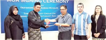  ??  ?? Sabah Museum deputy director Arif Abd Hamid (second left) exchanging documents with ICTM PASEA executive chairman Professor Dr Mohd Anis Md Nor after signing the MoA.