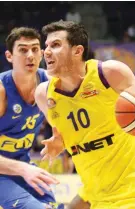  ?? (Adi Avishai) ?? HAPOEL HOLON’S Guy Pnini (10) drives to the hoops past Maccabi Tel Aviv’s Jake Cohen during Holon’s 100-95 victory over the yellow-and-blue on Sunday night in BSL action.