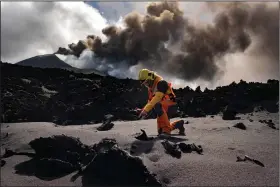  ?? (AP/Taner Orribo) ?? Scientists from around the world flocking to an eastern Atlantic Ocean island are using an array of new technologi­es available to them in 2021 to scrutinize — from land, sea, air, and even space — a rare volcanic eruption. A scientist from the Geological and Mining Institute of Spain from Spanish National Research Council measures the temperatur­e of lava on Nov. 5.