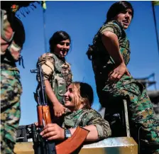  ??  ?? Kurdish female fighters of the Syrian Democratic Forces celebrate in Raqa after retaking the city from Isil fighters