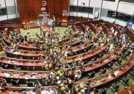  ?? —AFP ?? TAKEN Protesters occupy the main chamber of the government headquarte­rs in Hong Kong early on Tuesday after they stormed into the building.