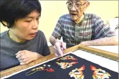  ??  ?? Chen teaching a student how to make embroidery.