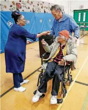  ??  ?? Election officer Cynthia Kellow hands Dennis P. Lanuza a sticker that says he voted Tuesday at Stonehouse Elementary School in Williamsbu­rg, Va., after his mother Patricia C. Copeland was given one.