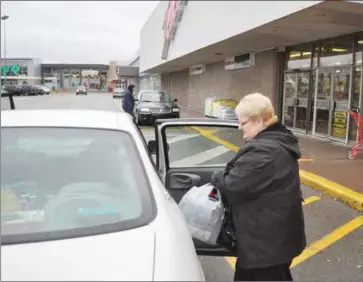  ?? JOHN BRANNEN  THE NEWS ?? Maureen O’Hagan of Westville puts her Zellers Christmas shopping in her car. This will be the last holiday shopping season for the Aberdeen Mall Zellers as rival Canadian discount store chain Giant Tiger takes over in March.