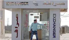  ?? — AFP ?? A Jordanian man opens his currency exchange shop at the Jaber border crossing between Jordan and Syria on the day of its reopening, in the Jordanian Mafraq governorat­e.