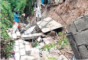  ?? RICARDO MAKYN/MULTIMEDIA PHOTO EDITOR ?? Residents viewing a collapsed wall at 19 Harbour Drive in Harbour View, St Andrew following heavy rains recently.