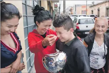  ?? James Rodriguez For The Times ?? SYLVIA CASTILLO hugs nephew Erik, 12, as his mother and grandmothe­r look on in Guatemala City. Erik spent four months in detention in Chicago after he and his father were separated at the U.S. border.