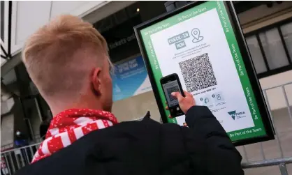  ??  ?? A man checks in at AAMI Park in Melbourne. Victoria and NSW will require vaccine passports to enter major events, but the ACT government says it will not do so in Canberra. Photograph: Dave Hewison/Speed Media/Rex/Shuttersto­ck