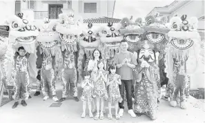  ?? ?? PELIHARA TRADISI: Ling dan ahli keluarga bergambar dengan lapan singa dari Persatuan Tarian Singa dan Naga Wai Sheng Miri sempena Sambutan Cap Goh Mei, semalam.